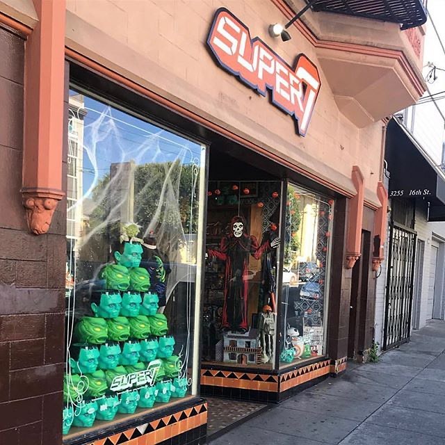 Storefront with a bright Super7 sign and window displays featuring green Hulk heads.