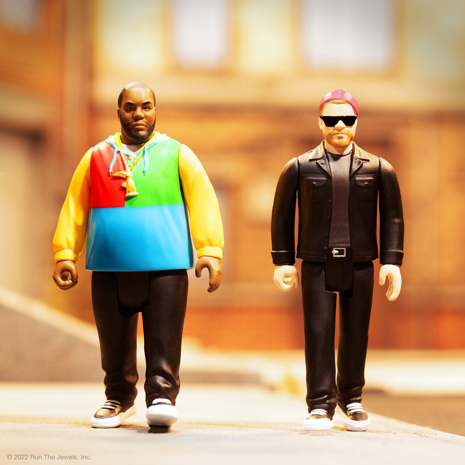 Run The Jewels ReAction Figures pair with one wearing a bright color block hoodie and the other in a black leather jacket with sunglasses