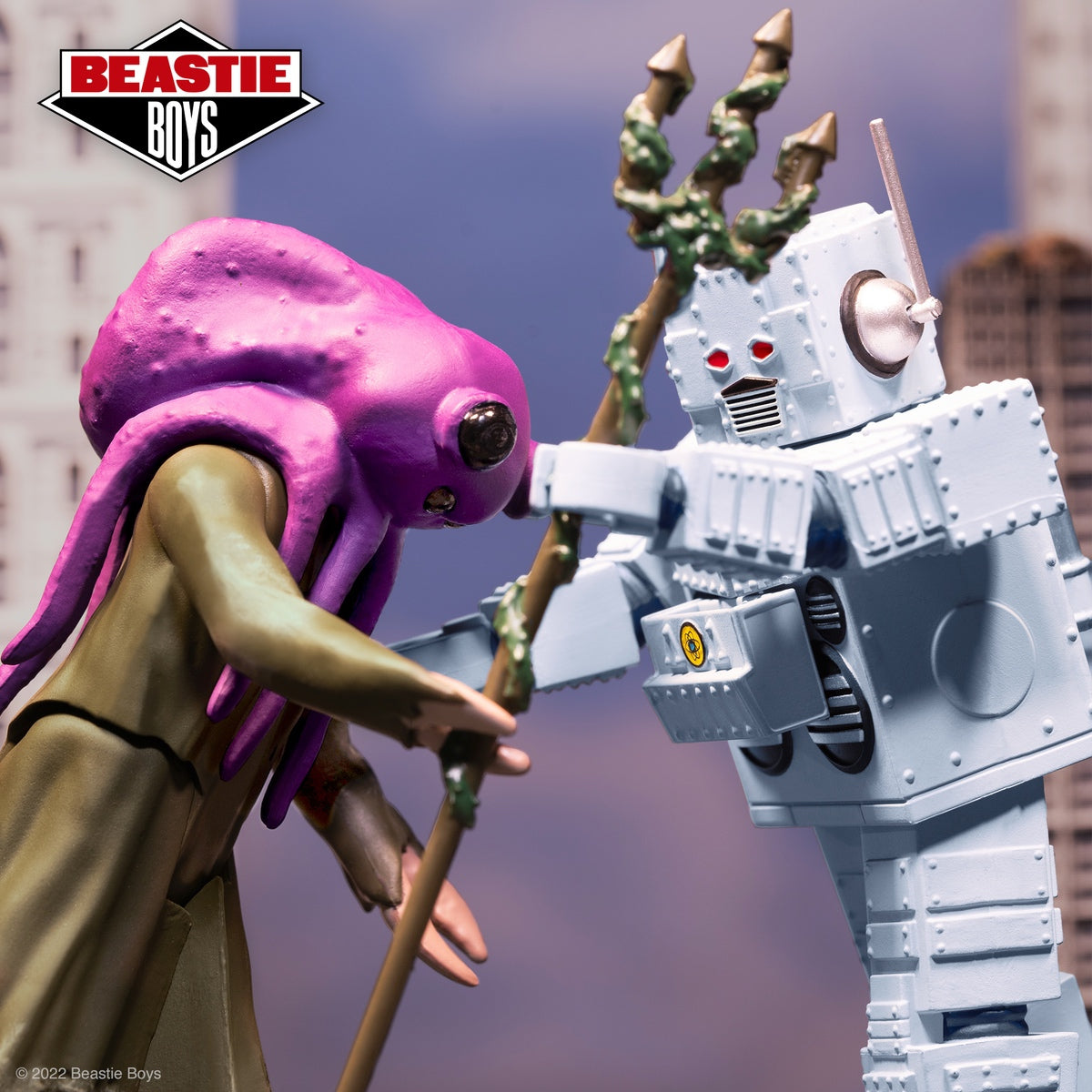 Beastie Boys themed figure set showing a purple alien clashing with a gray robot against a city backdrop.