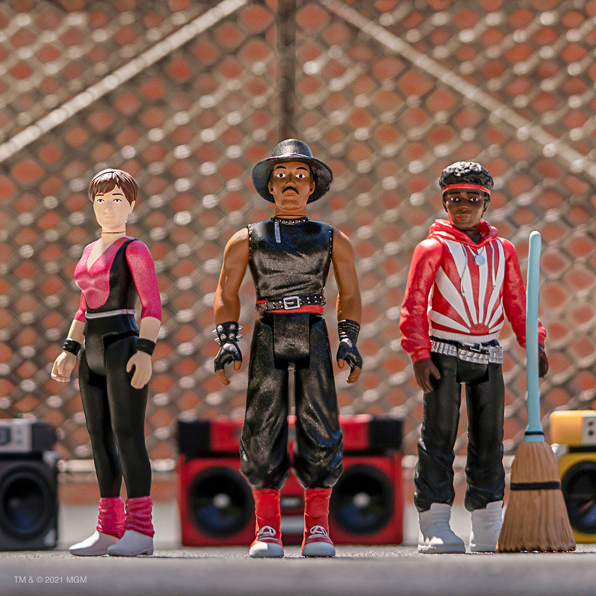 Break It To Make It action figures posed outdoors against a chain link fence.