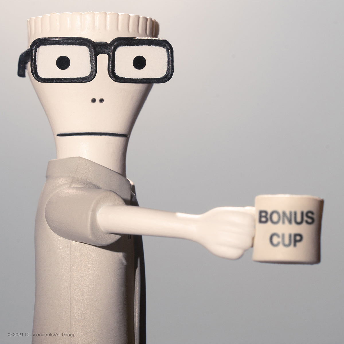 White cartoonish action figure with thick black glasses holding a mug labeled BONUS CUP