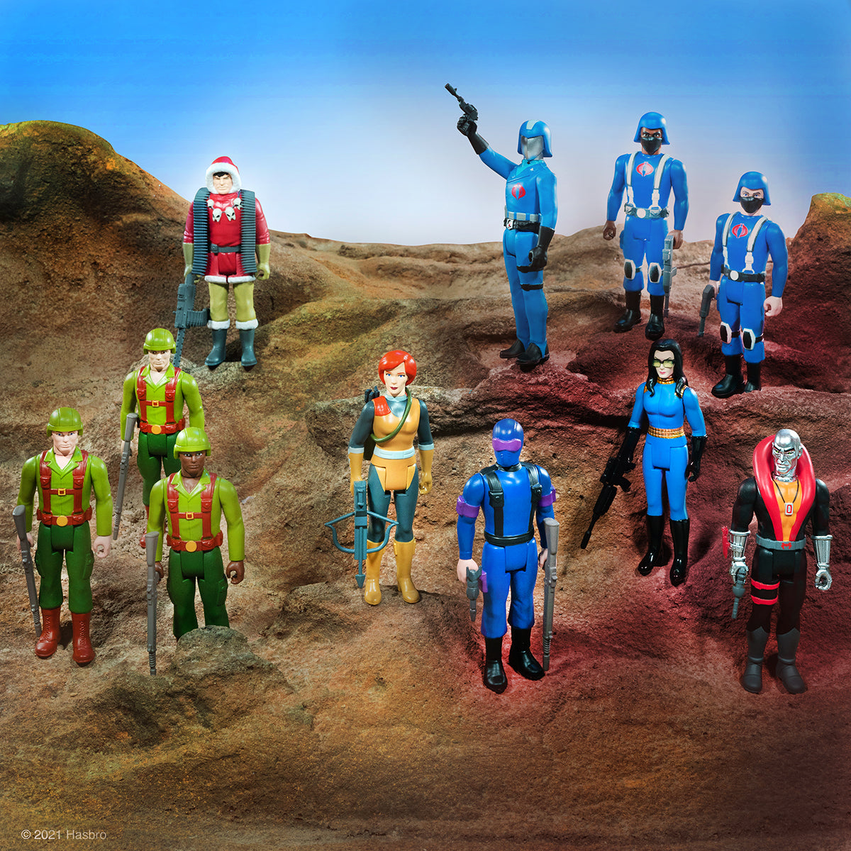 G.I. Joe and Cobra action figures posed on a rocky desert battlefield for the Super7 ReAction line.