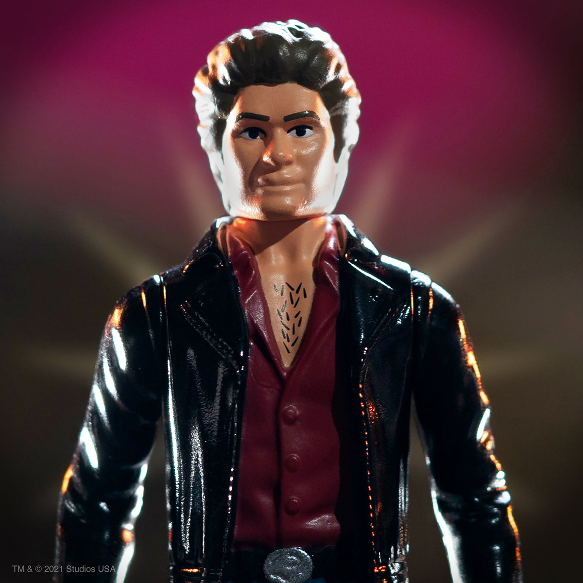 Close up of a rugged action figure in a black leather jacket and red shirt with a chest tattoo