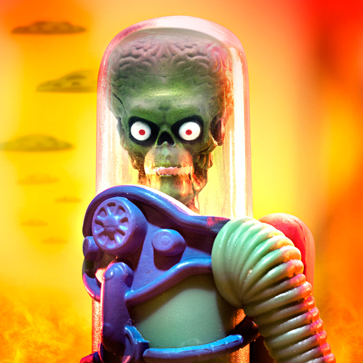 Mars Attacks alien in a glass dome with a row of colorful aliens in white suits against a warm gradient backdrop.