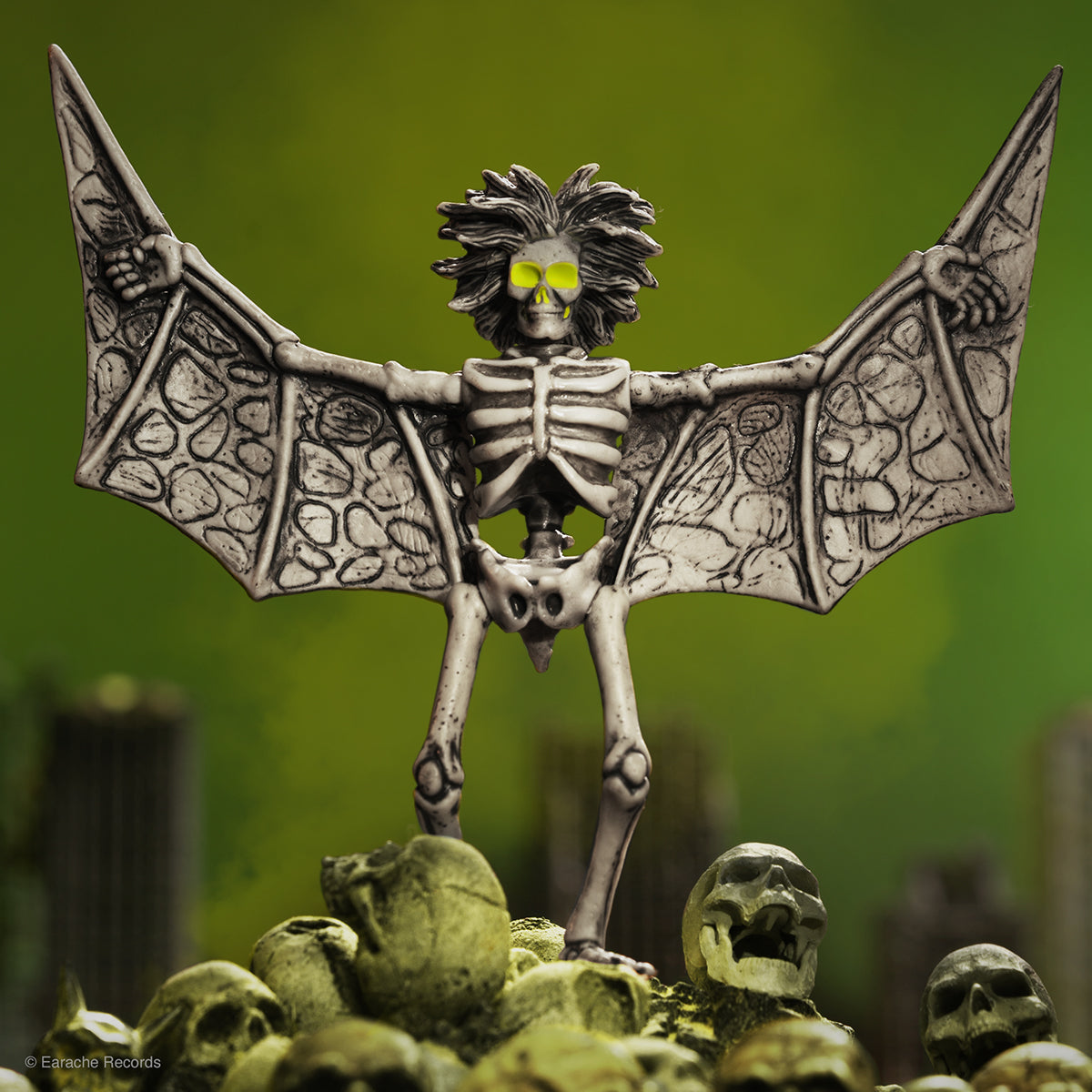 Napalm Death Super7 collaboration figure a skeletal bat creature with outstretched wings perched on a rocky mound with skulls.