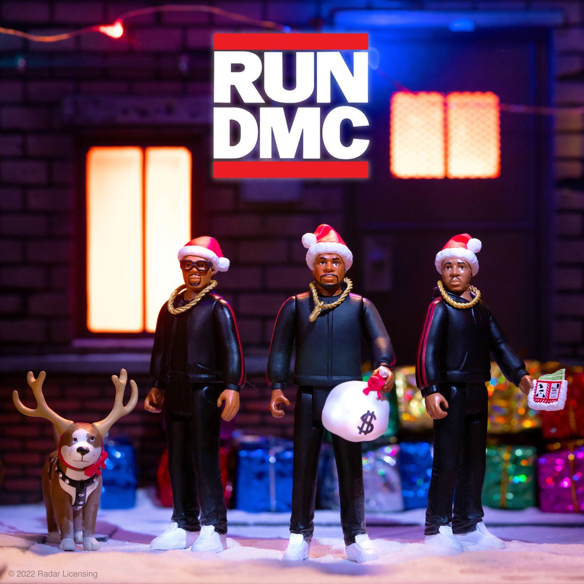 Holiday display with three Santa-hat wearing action figures and a dog in front of a RUN DMC sign on a snowy street.