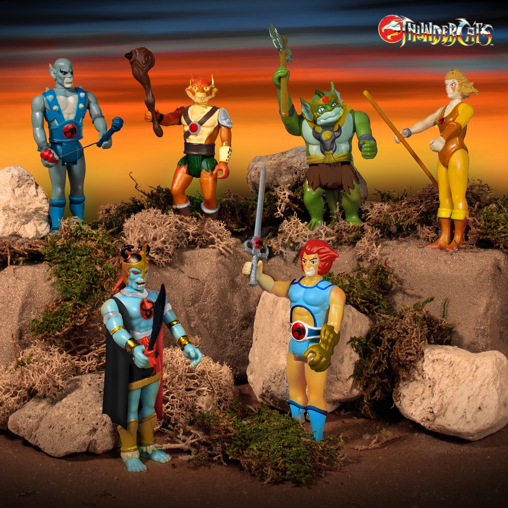 Thundercats ReAction figures lineup posed on a rocky desert set at sunset with the ThunderCats logo in the corner