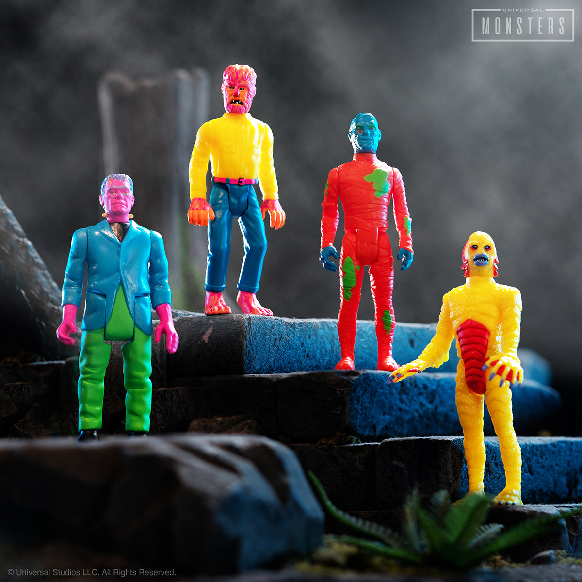 Brightly colored Universal Monsters 70s costume ReAction figures lineup on a rocky diorama