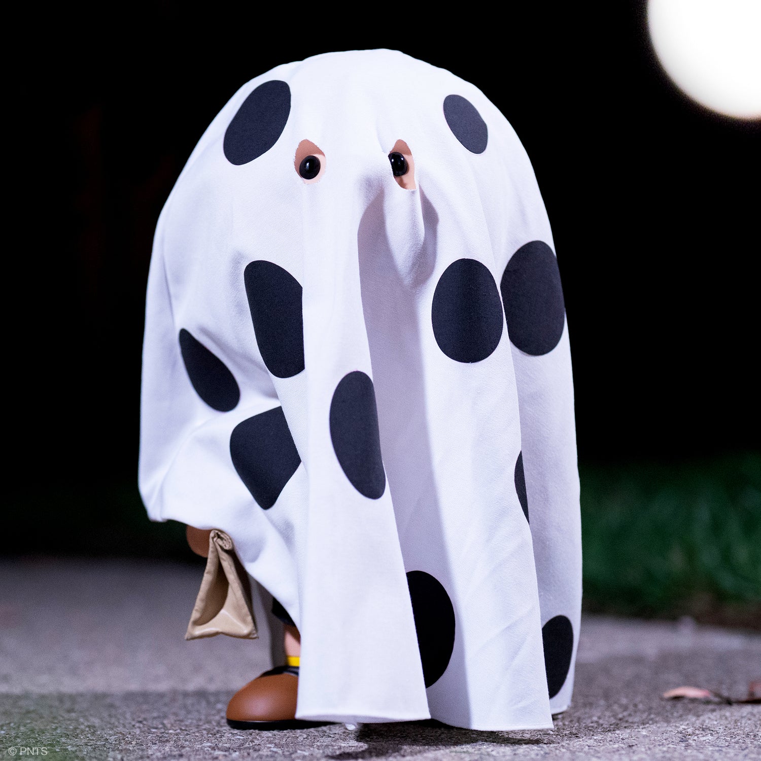 Peanuts Charlie Brown hidden under a large white ghost sheet with eye holes.