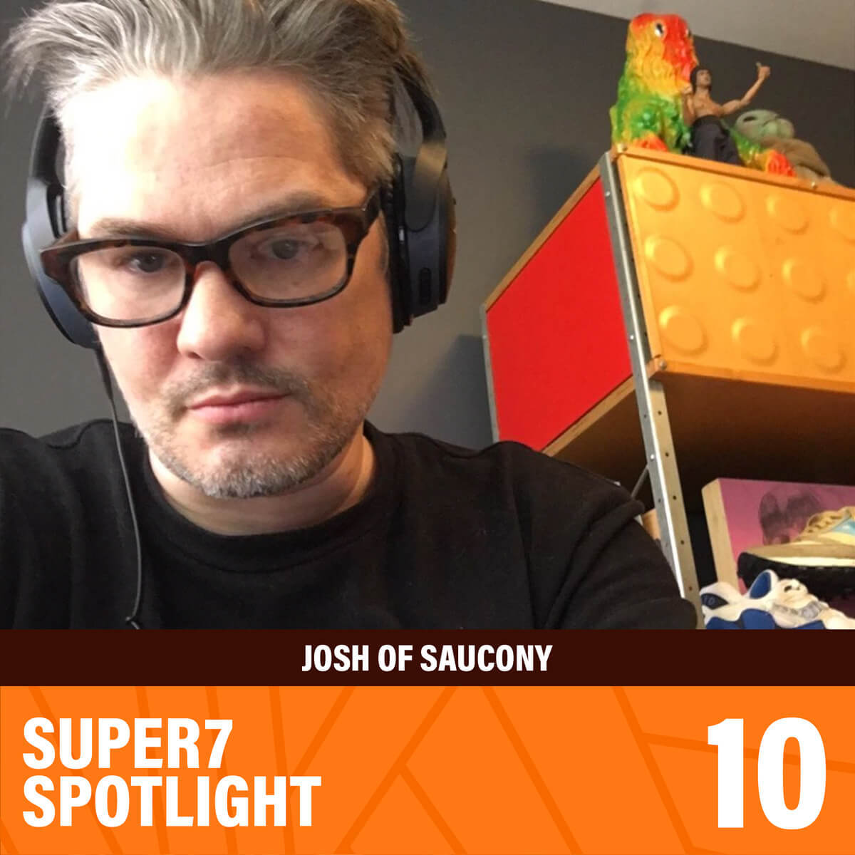 Josh Fraser of Saucony wearing headphones in a room with shelves and bright toys in the background