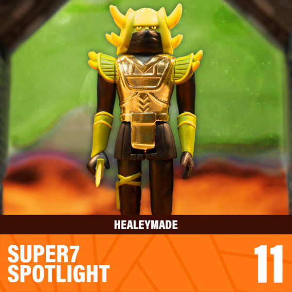 Healeymade gold armored action figure on a rocky display with the Healeymade banner and Super7 Spotlight branding