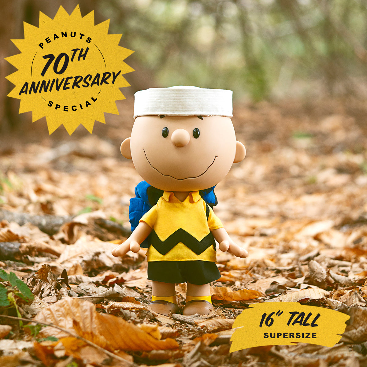 Charlie Brown from Peanuts with a blue backpack standing among autumn leaves for the 70th anniversary supersize release
