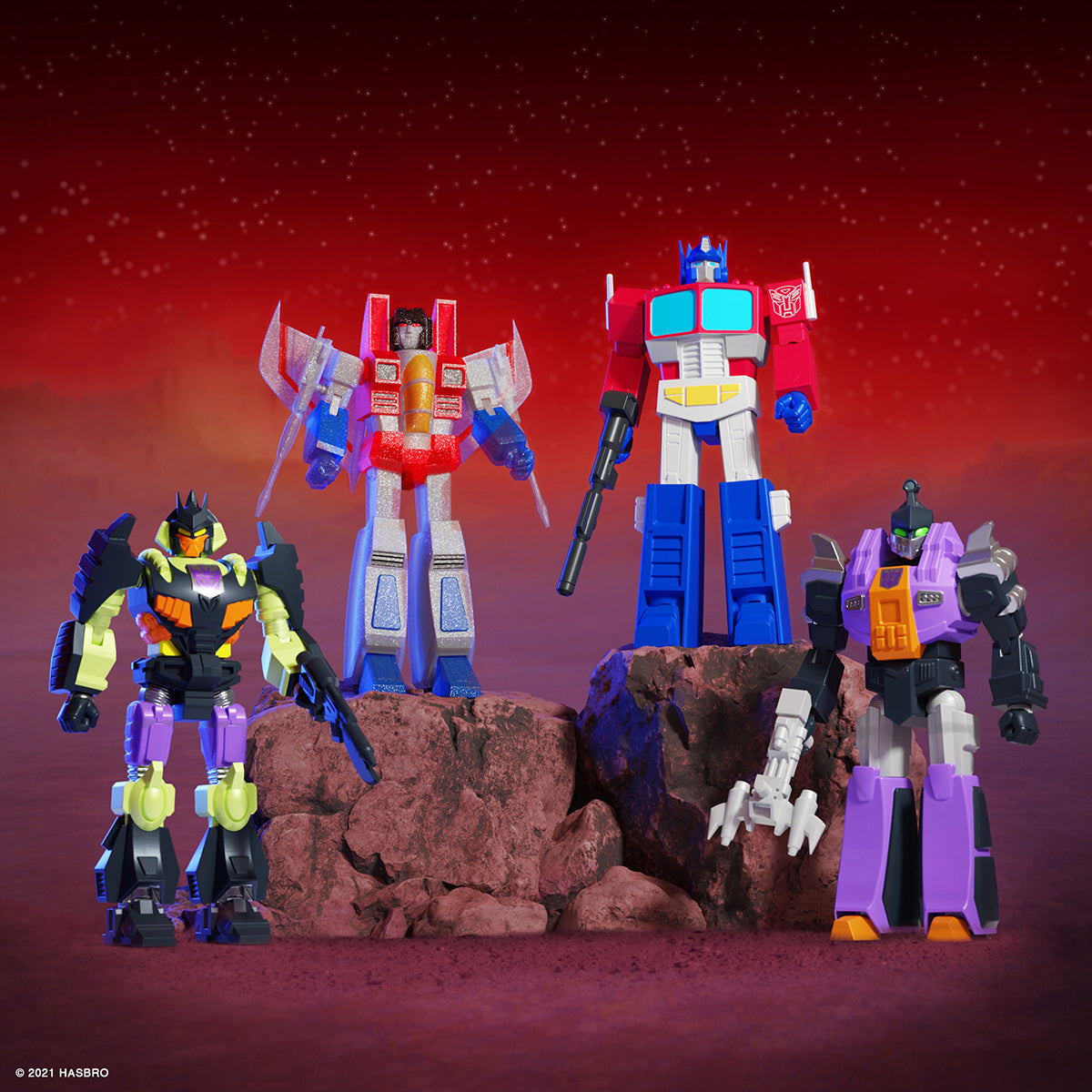 Group of Transformers Ultimates wave 1 figures posed on rocky outcrop against a red sky
