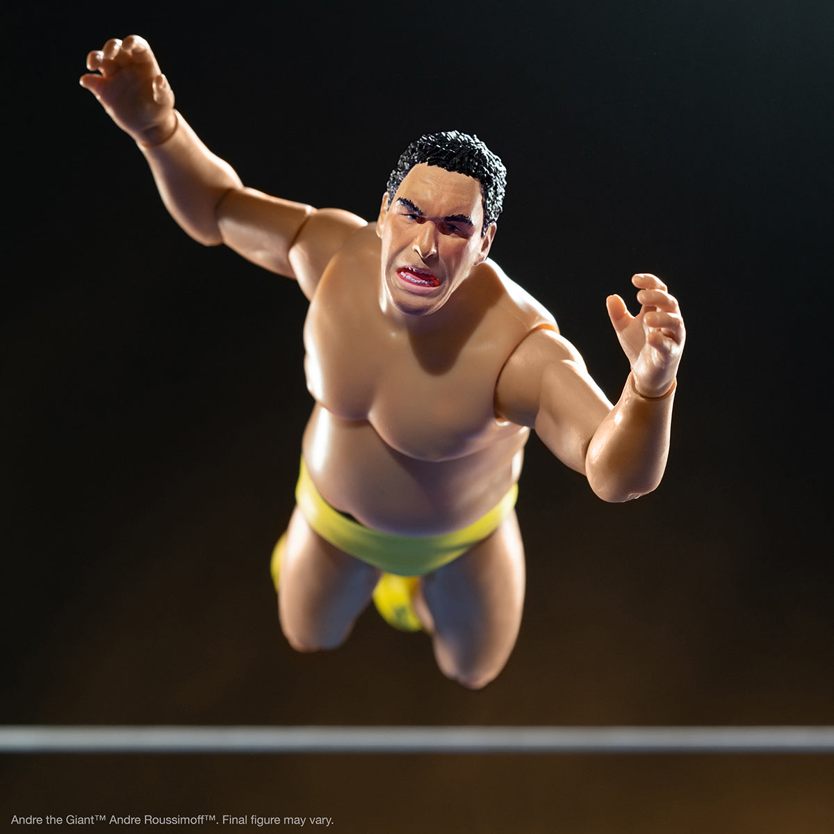 Andre the Giant Ultimate wrestling figure leaping midair in yellow trunks against a dark background