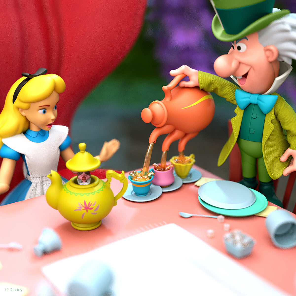 Alice and the Mad Hatter figurines at a whimsical tea party with a bright yellow teapot and small cups