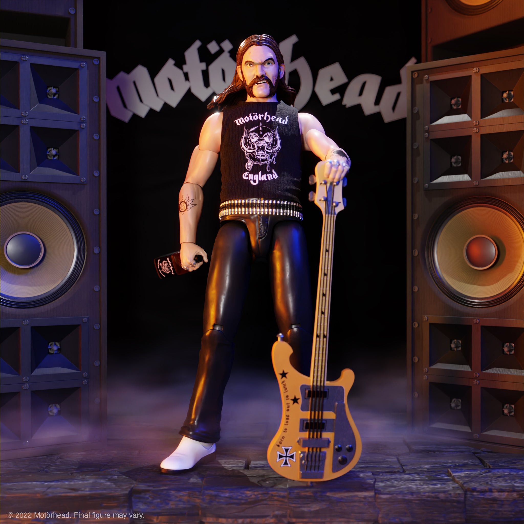 Lemmy Motörhead action figure in a sleeveless black shirt with a guitar, posed among oversized stage speakers.