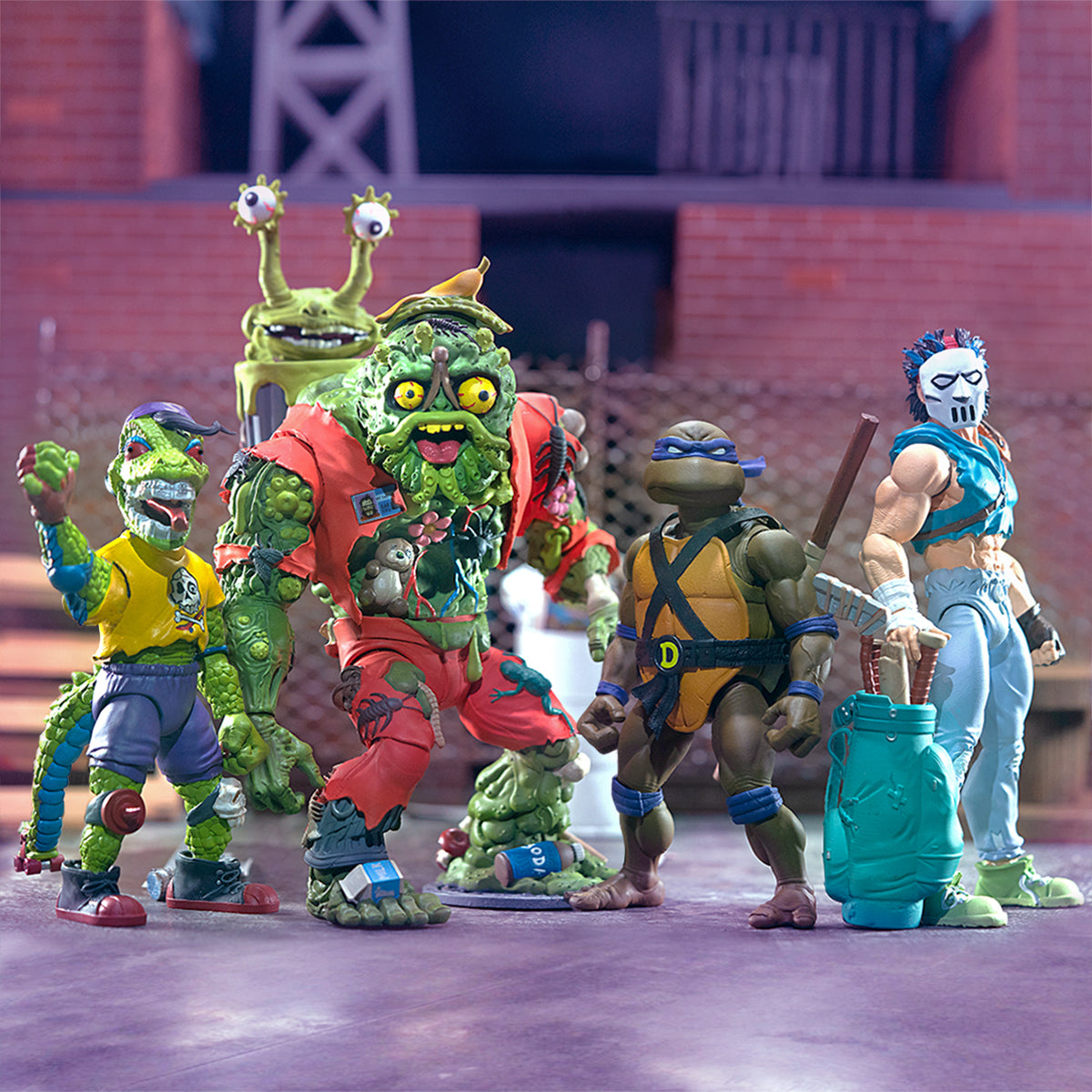 Five Teenage Mutant Ninja Turtles Ultimates Wave 4 figures posed together on a city street with a brick building backdrop