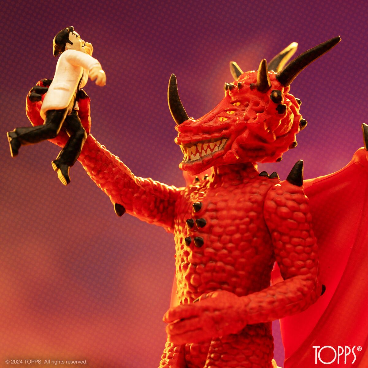 Red dragonlike alien action figure with outstretched arms against a purple sky.