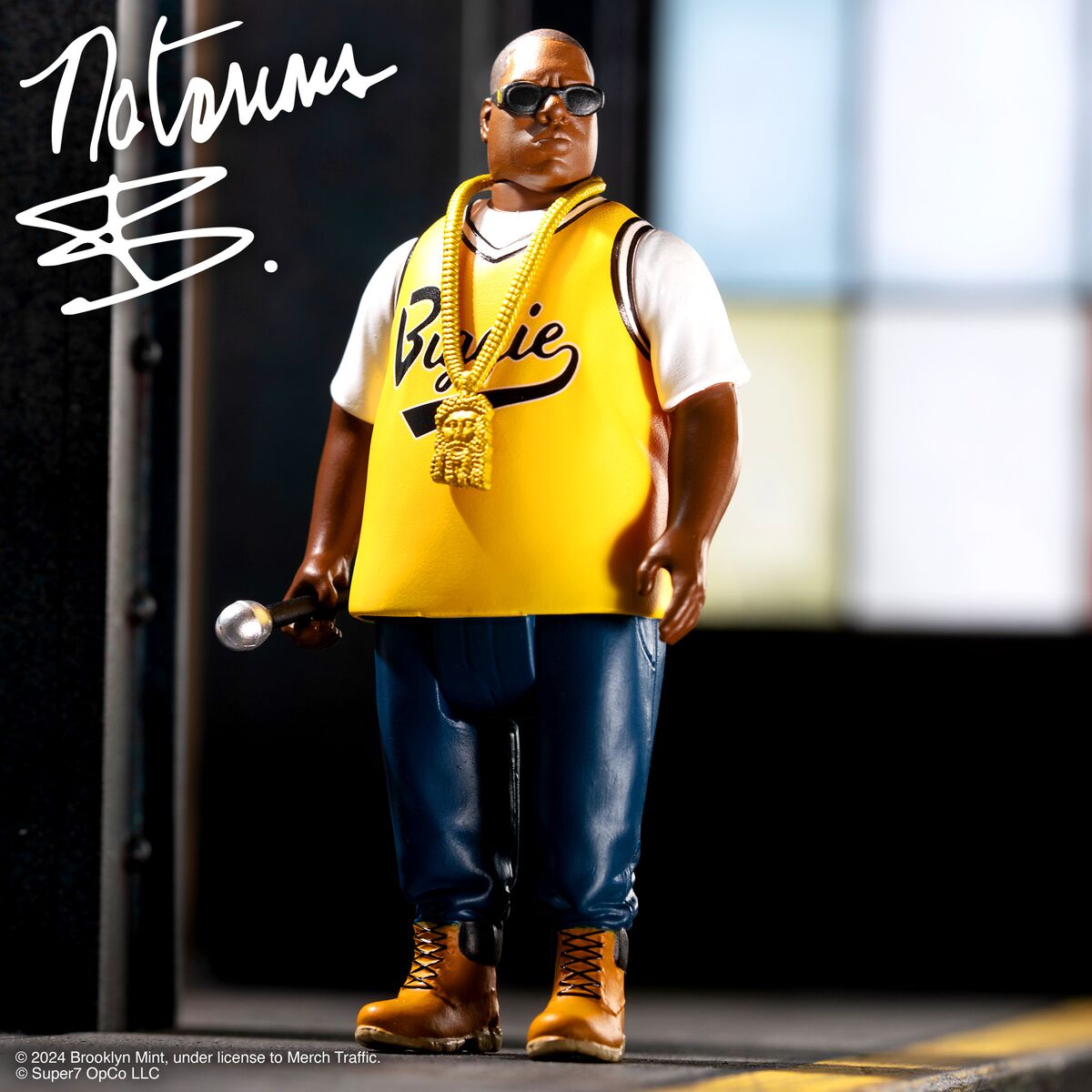 Hip hop action figure wearing a yellow basketball jersey a gold chain sunglasses and holding a microphone on stage