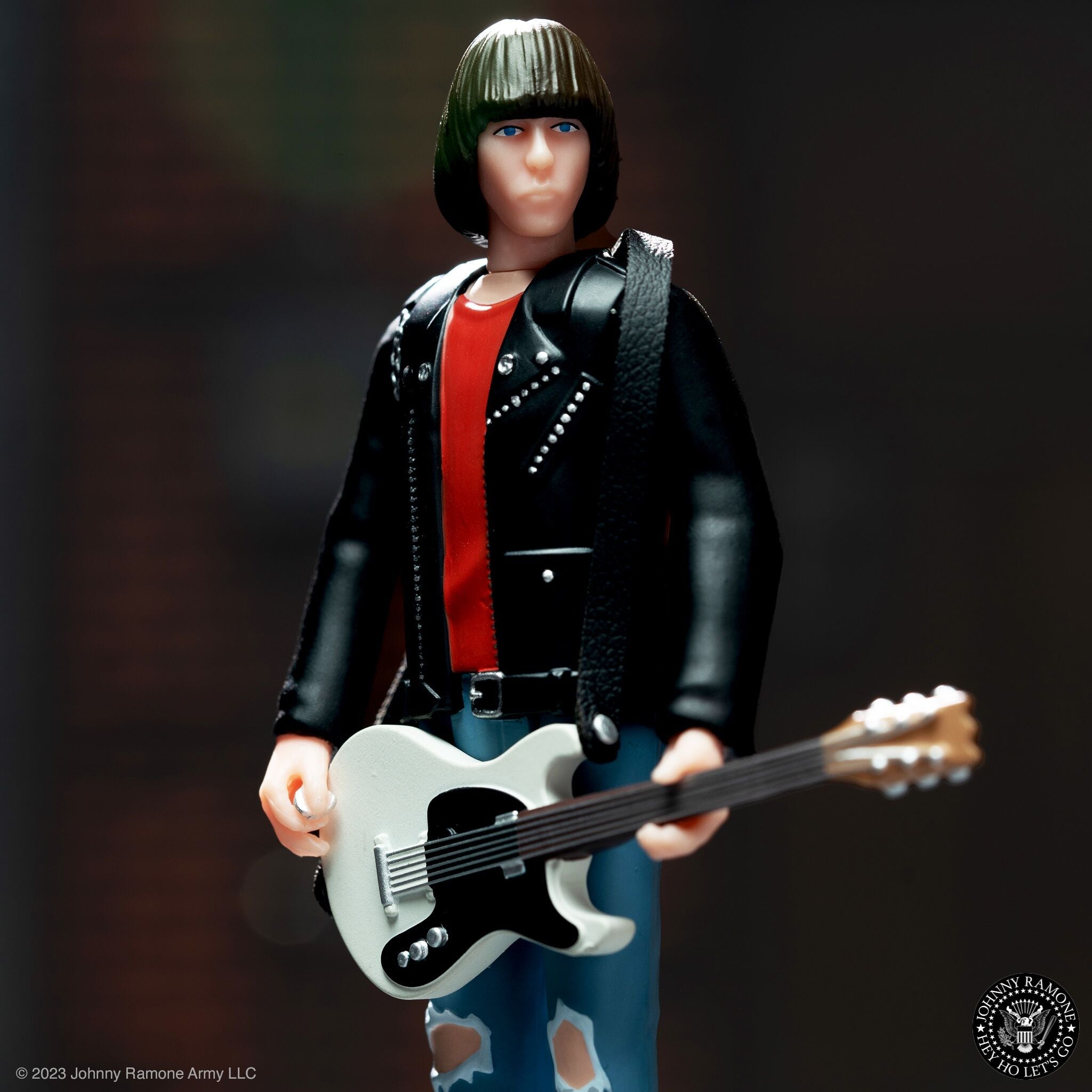 Johnny Ramone collectible action figure in a studded black jacket with a light gray guitar and flame details from the Johnny Ramone Army collection.