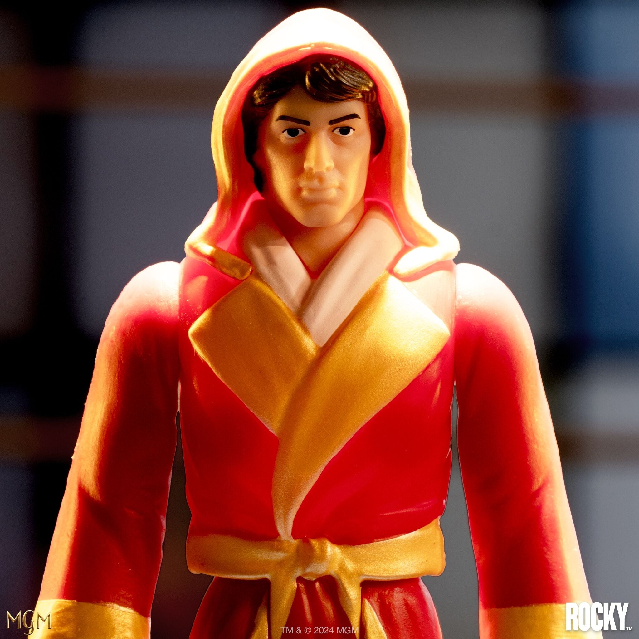 Close-up of a Rocky action figure in a red and gold hooded robe.
