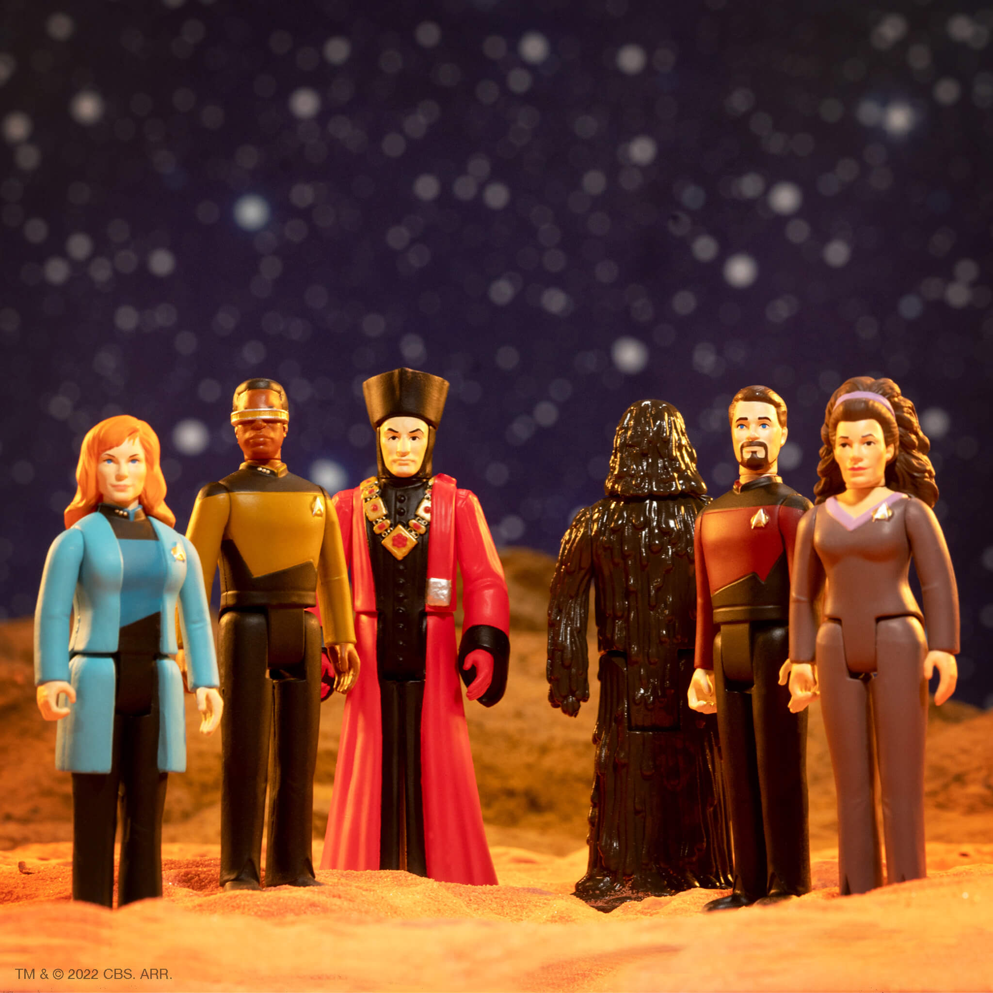 Group of movie and TV character figurines lined up against a starry backdrop