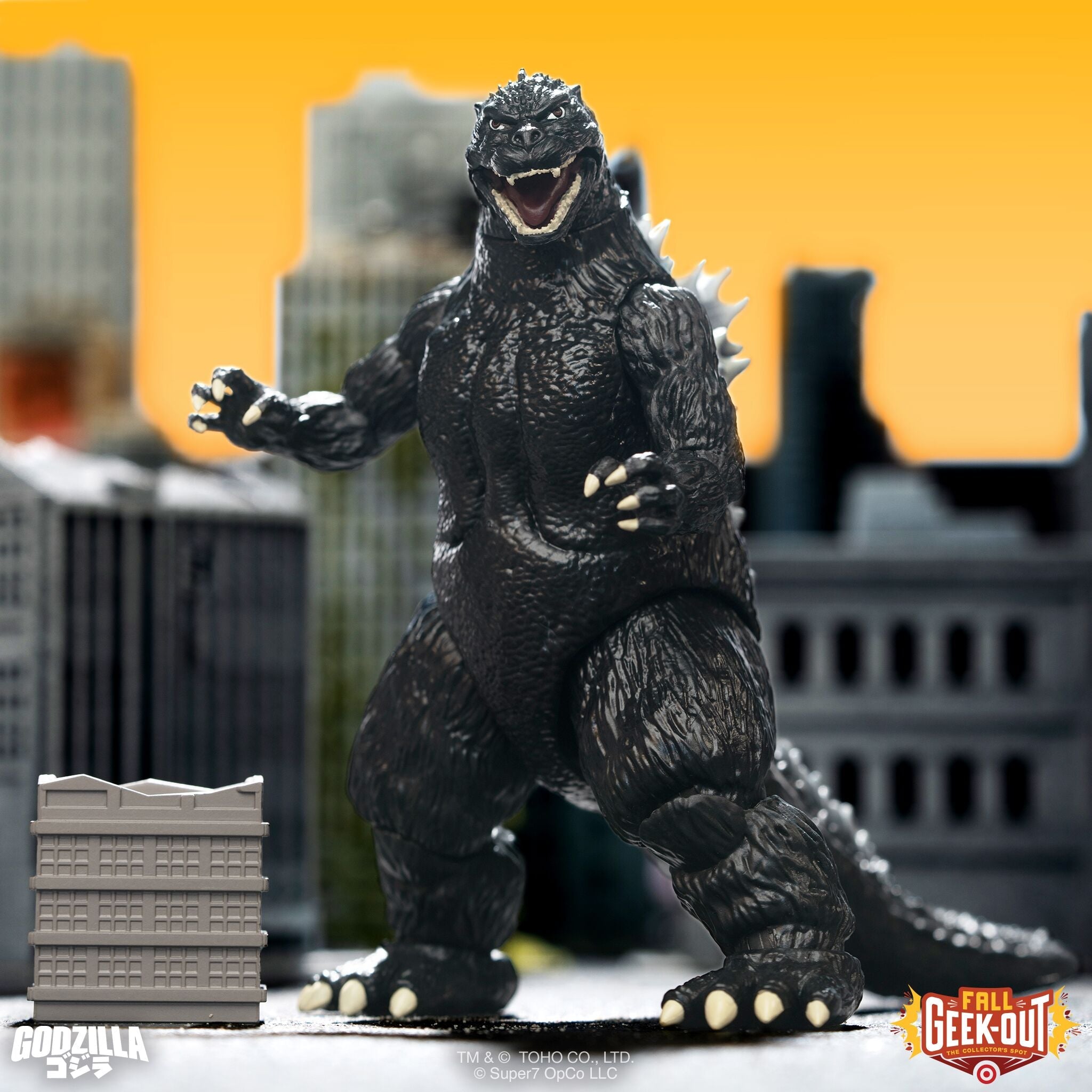 Black Godzilla style kaiju figure with yellow eyes and open mouth on a red lit stage