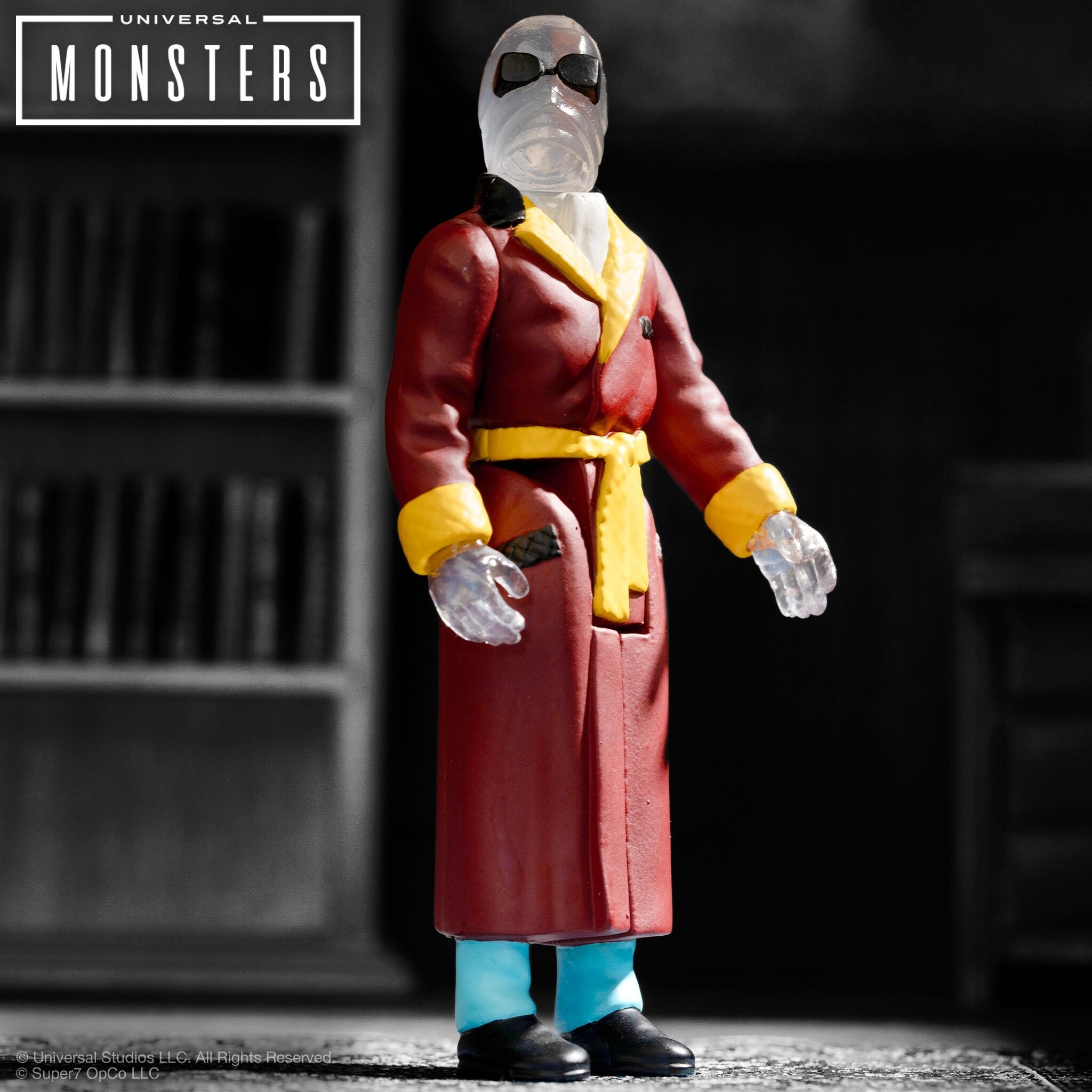 Gray action figure with blue accents raises a weapon against a dark blurred background