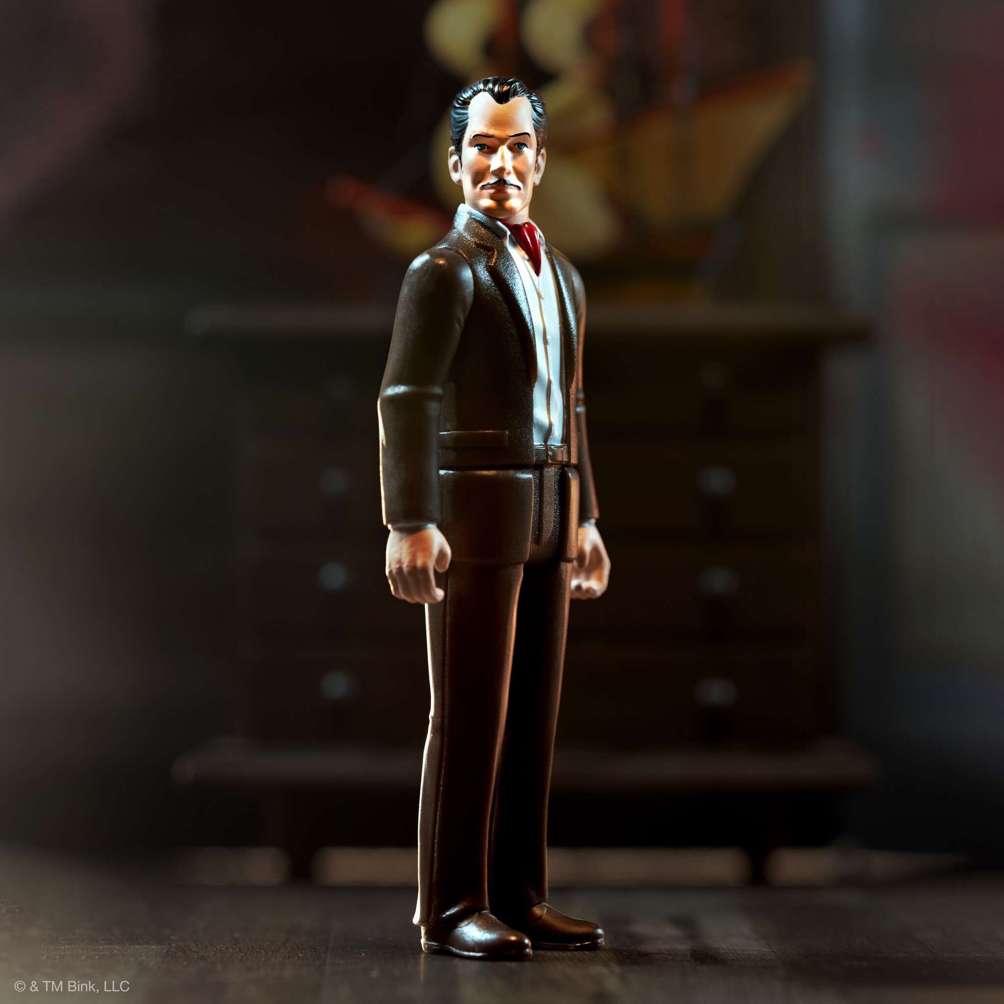 Vincent Price style figurine in a dark suit and red tie