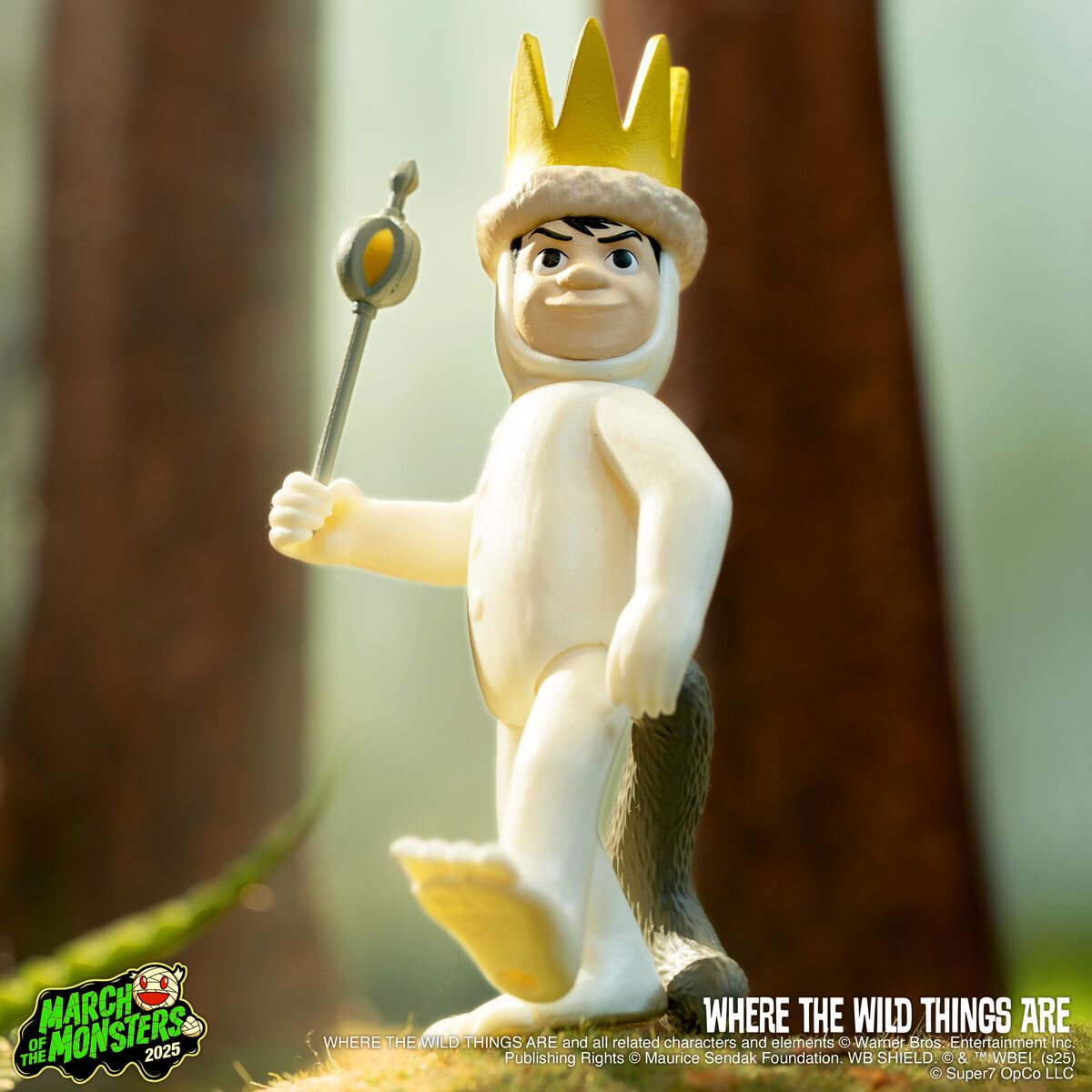 King figure from Where the Wild Things Are wearing a gold crown and holding a scepter in a forest setting.