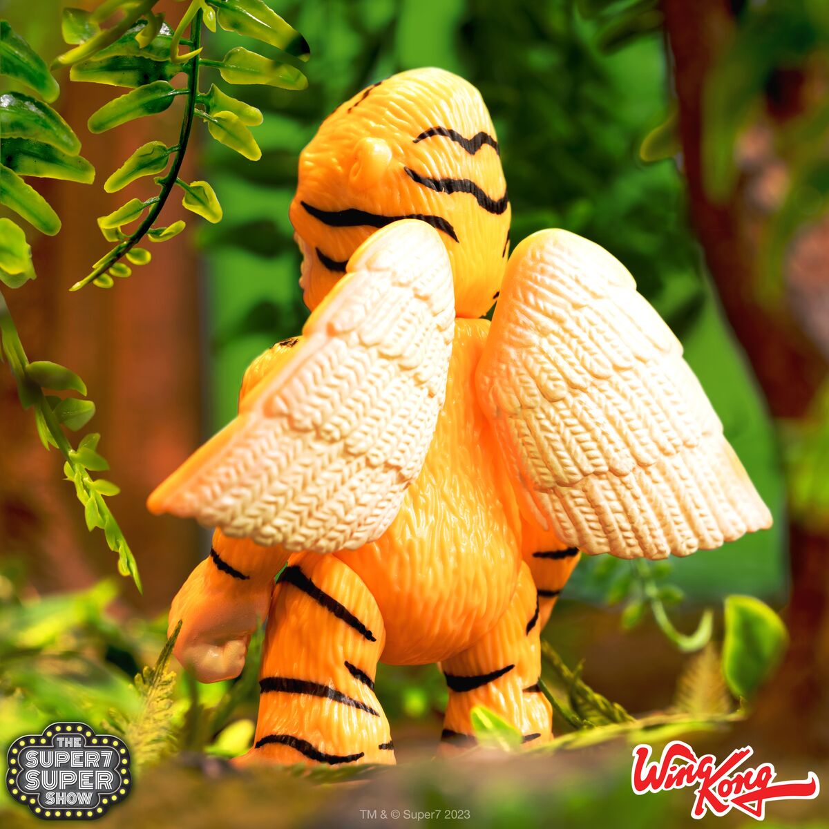 Orange winged tiger figure from Wing Kong collection in a lush green backdrop
