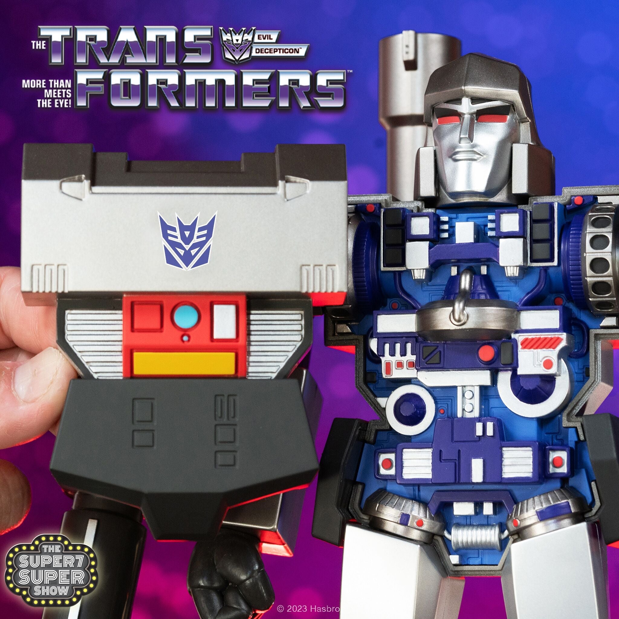 Close up of a metallic Transformer style figure against a purple background with a Super7 Super Show badge.