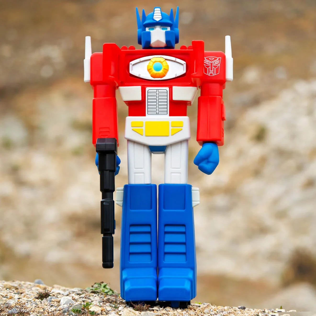 Super Shogun action figure with red torso white details and blue legs standing outdoors holding a black staff