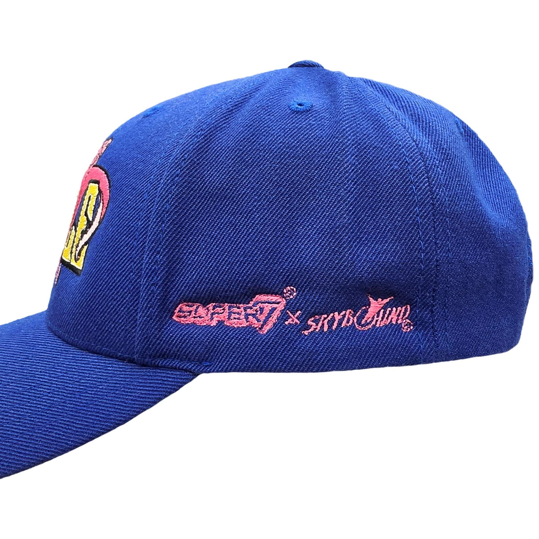 Blue baseball cap with pink embroidered Super7 x Skybound logo on the side