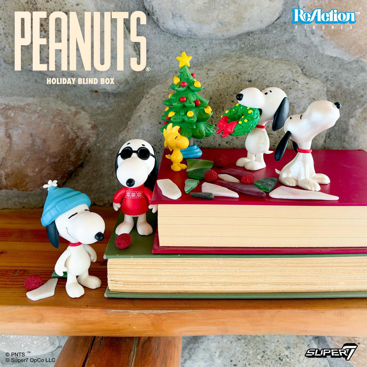 Peanuts ReAction Wave 11 Holiday display with Snoopy figures and a red blind box on a wooden table