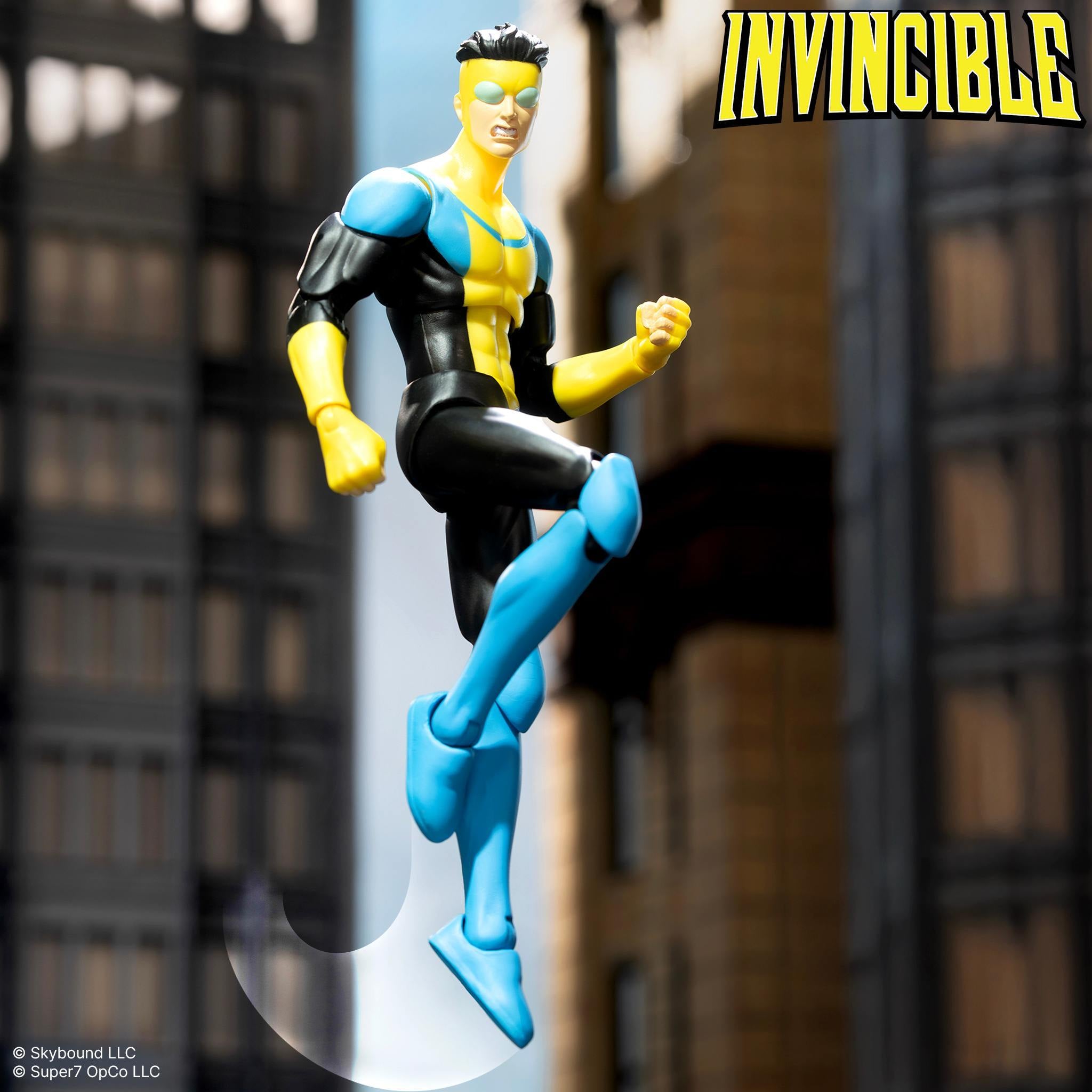 Invincible 7-inch DX Deluxe action figure flying between city buildings