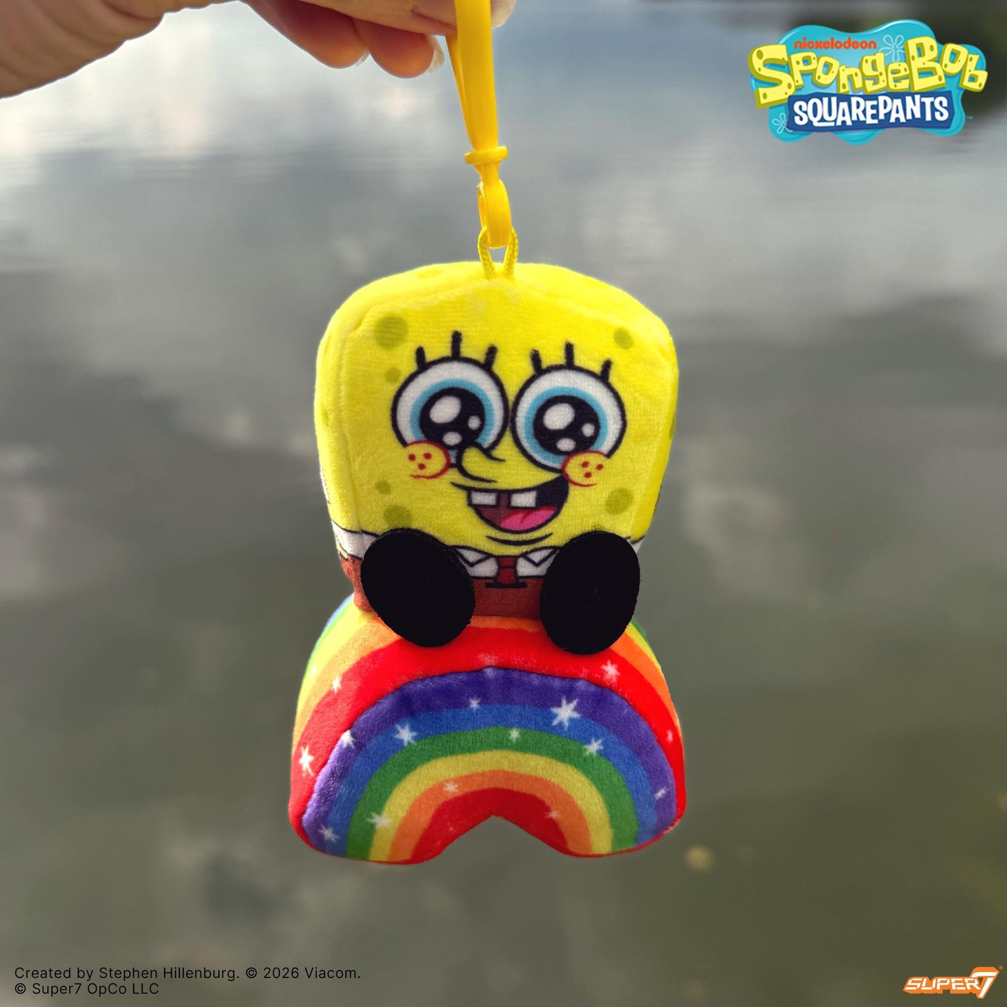 SpongeBob SquarePants plush keychain sitting on a rainbow