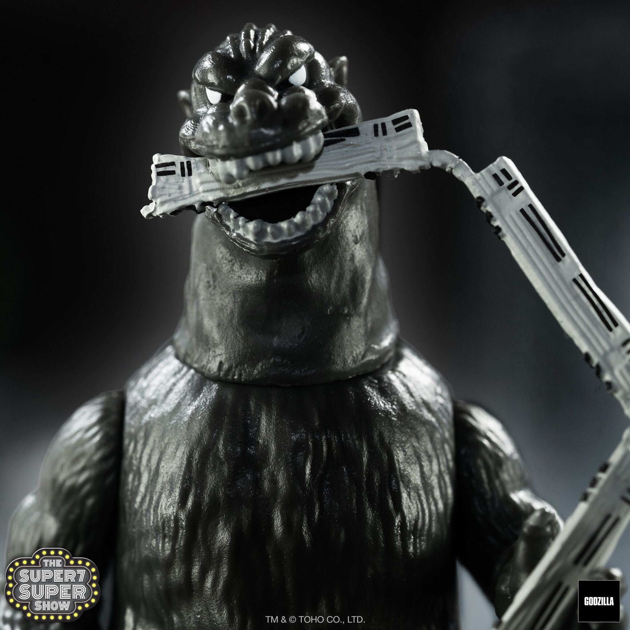 Toho ReAction Godzilla 1954 Train Biter close up of head gripping a gray train accessory