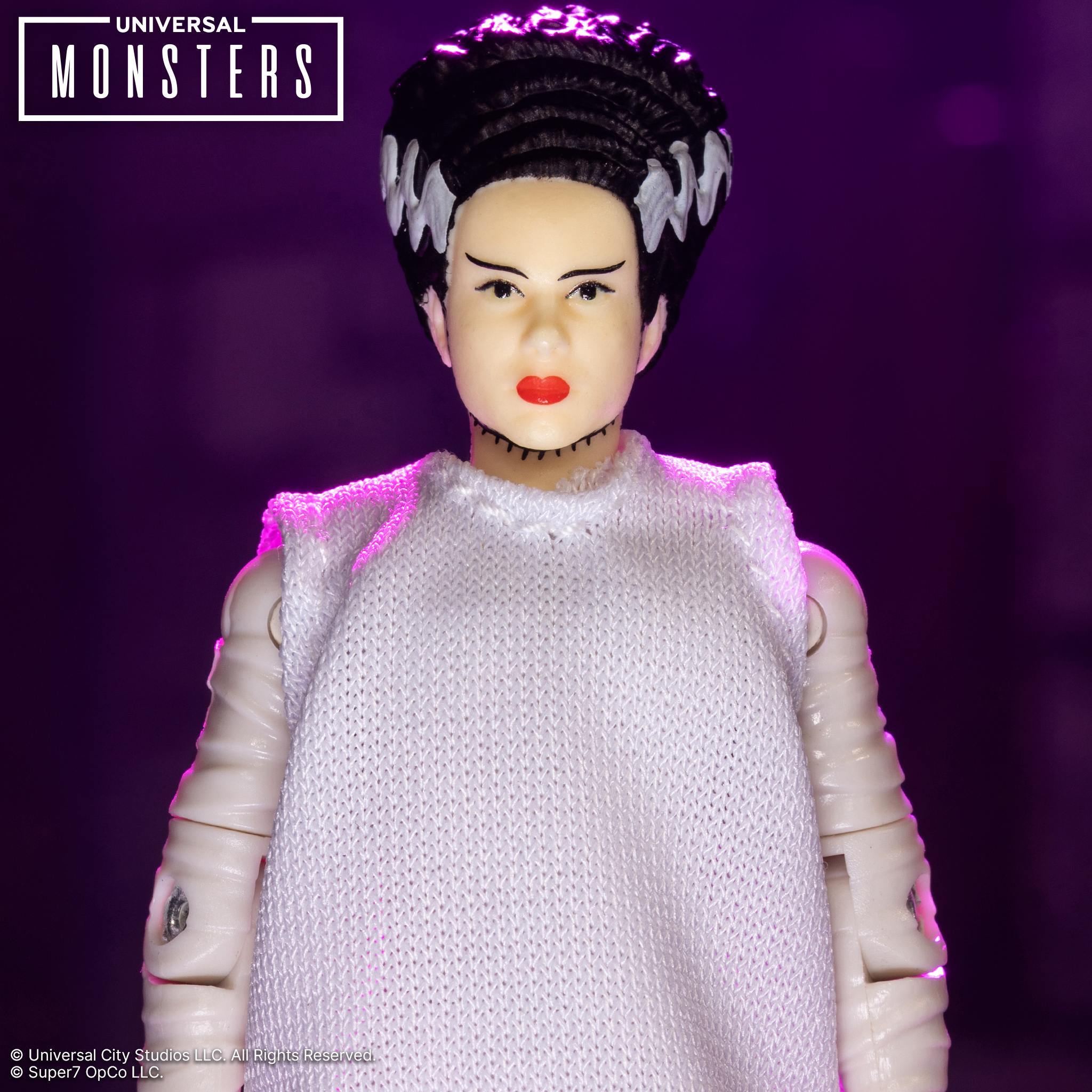 Bride of Frankenstein action figure with black hair and white streaks wearing a white dress