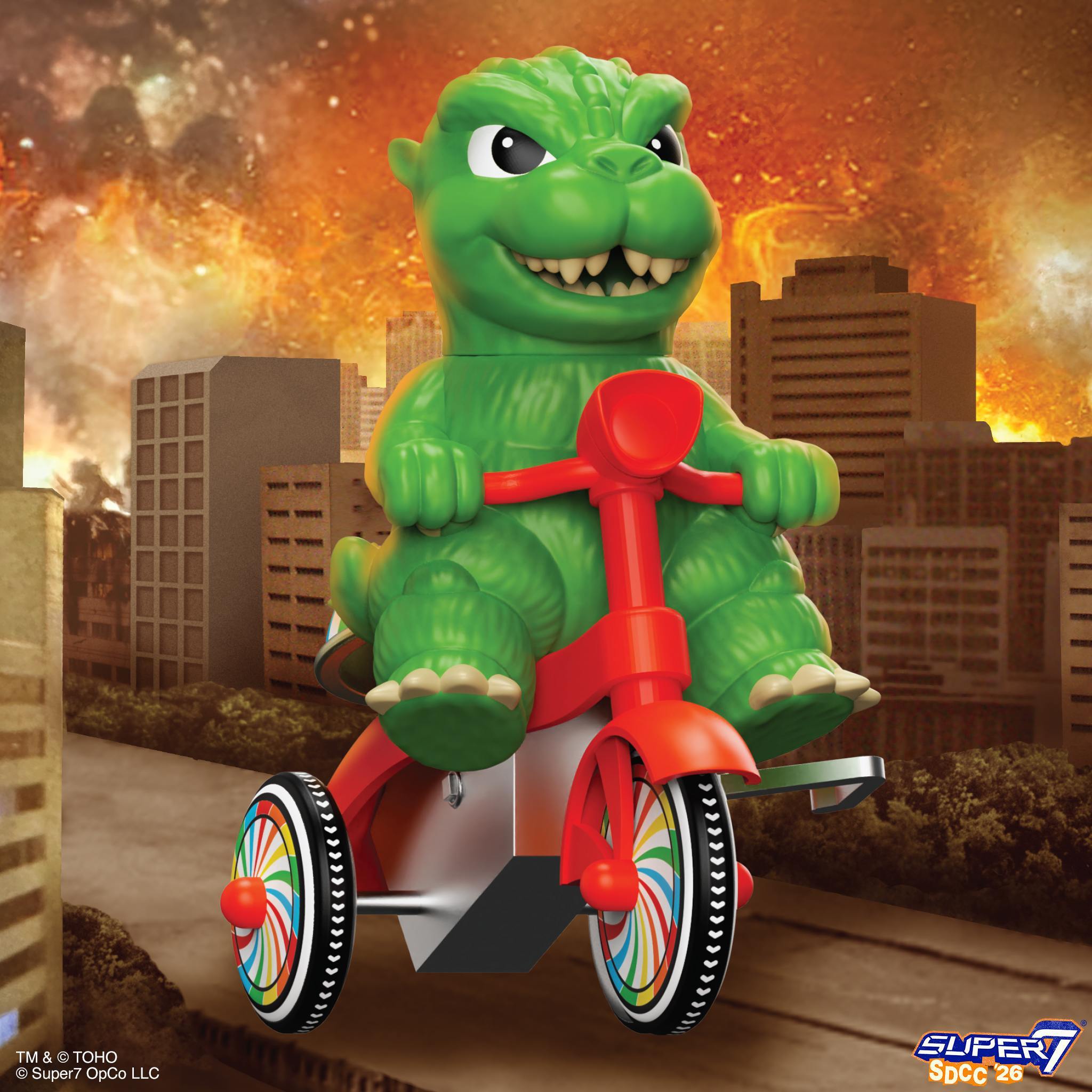 Close up of the green Godzilla head on a red tricycle with a fiery city background