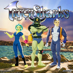 TigerSharks ULTIMATES! Wave 1 action figures Mako, Octavia, and T-Ray standing on rocks by the ocean