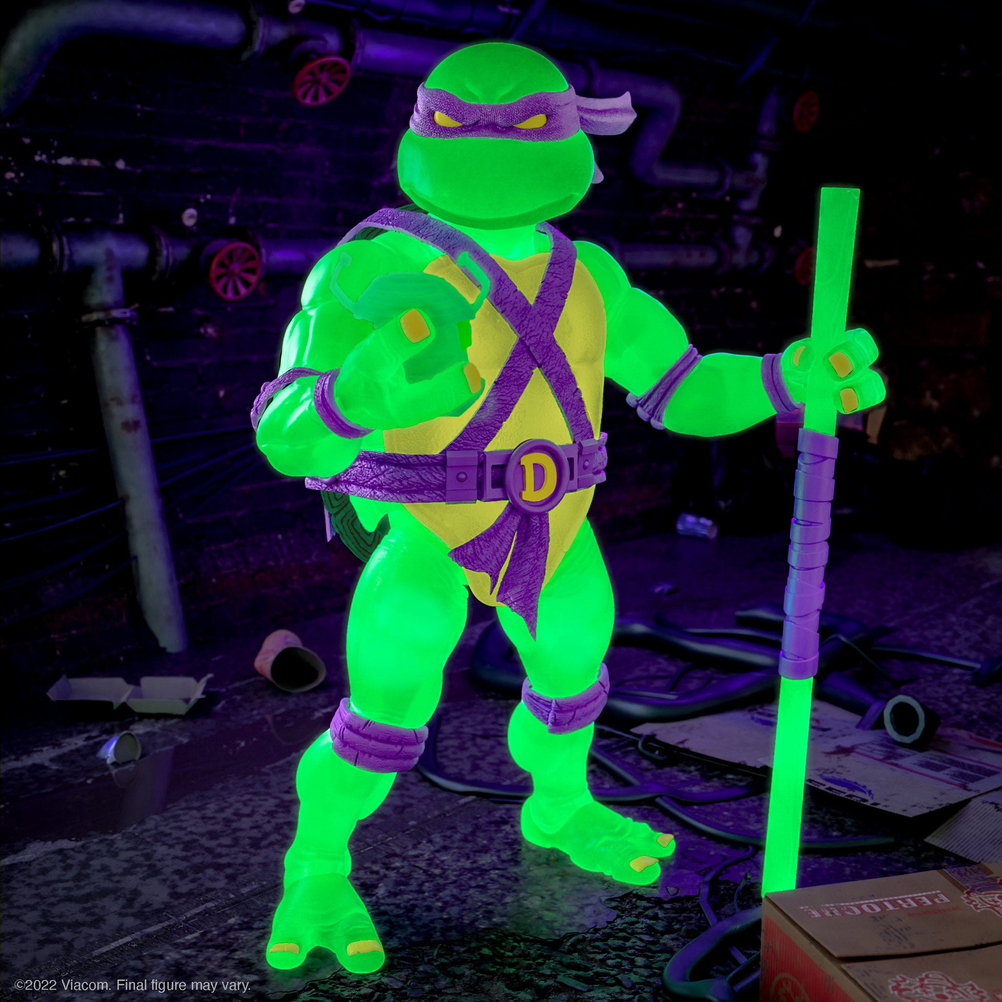 Donatello Mutagen Ooze Glow figure in a dark setting with neon green bo staffs and matching accessories
