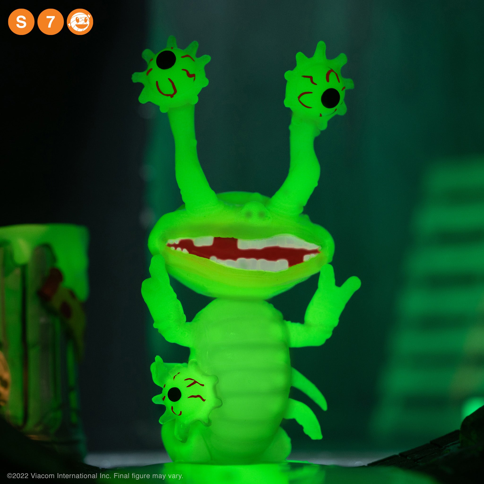 Two neon green eye stalk heads with red facial markings against a dark background of the display