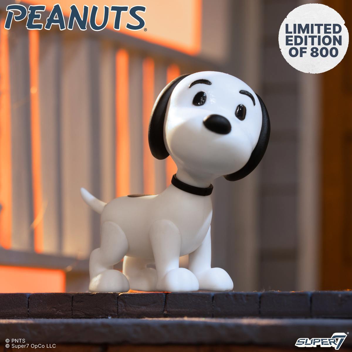 Snoopy figure from Peanuts on display with a limited edition badge and the Peanuts logo in the corner.