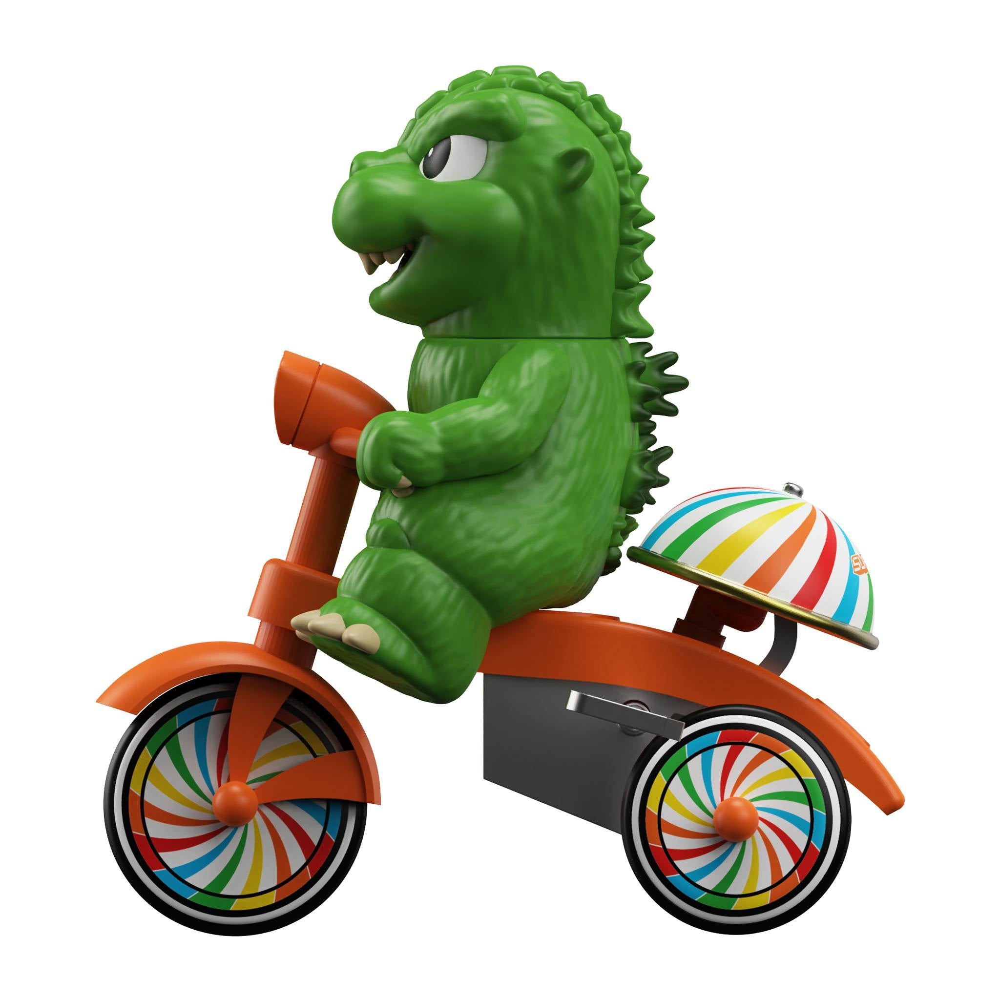 Toho Super Cycles Godzilla figure in green on an orange tricycle with rainbow wheels