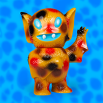 Bat Boy Cave Pox tan vinyl figure with large blue eyes against a bright blue background