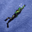 Close up of a neon green and yellow embroidered Creature from the Black Lagoon on blue knit fabric.